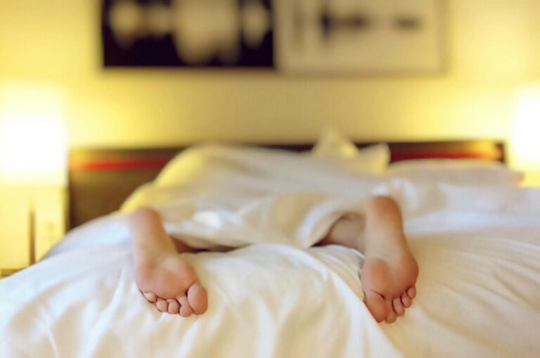 Person relaxing under a blanket on a Sunday morning — perfect visual for low-waste habits and lazy sustainability.